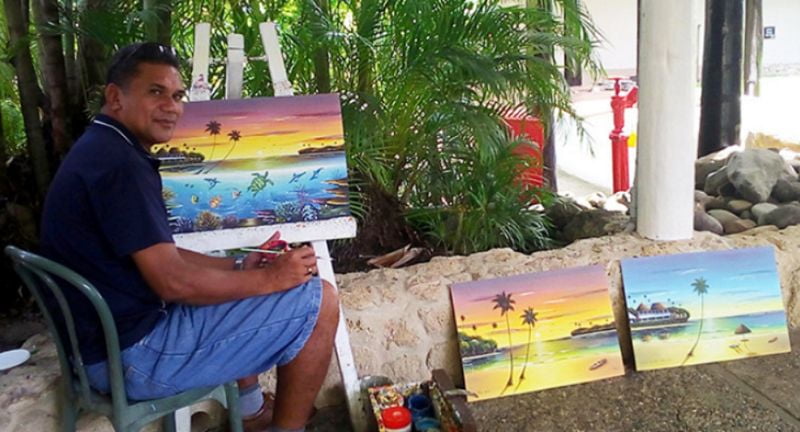 Timoci Sokoiwasa with his paintings at Shangri-La’s Fijian Resort. Photo: Charles Chambers